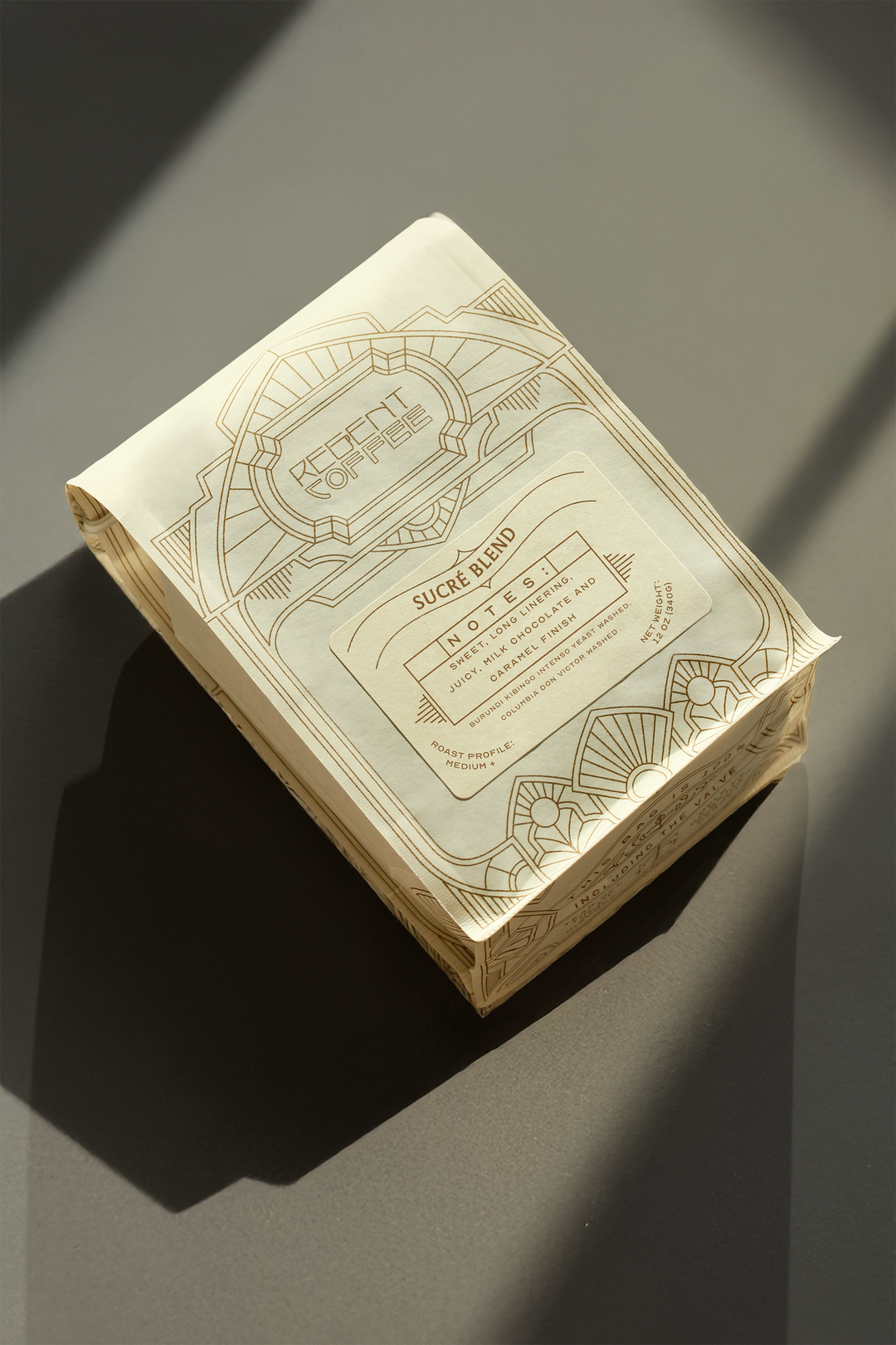 12 oz bag ofSucré Blend on a gray surface surrounded by shadows