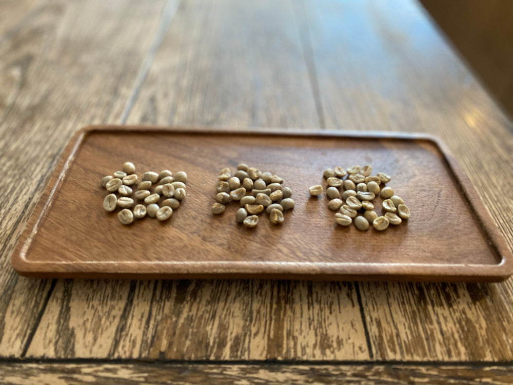 Crooked Blend green beans in 3 piles on a wooden plate at the Regent Coffee Shop