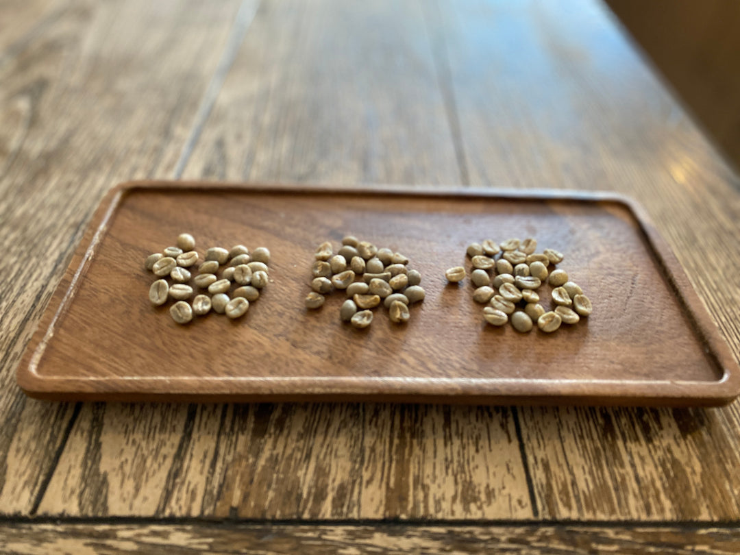 Crooked Blend green beans in 3 piles on a wooden plate at the Regent Coffee Shop