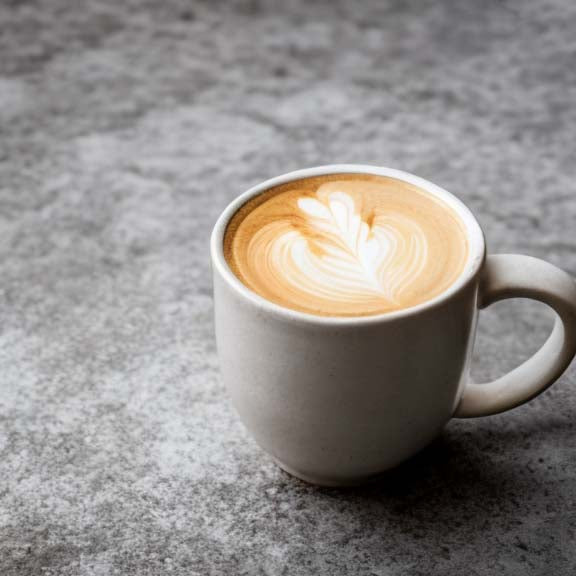 Creamy decaf latte with latte art in stone mug