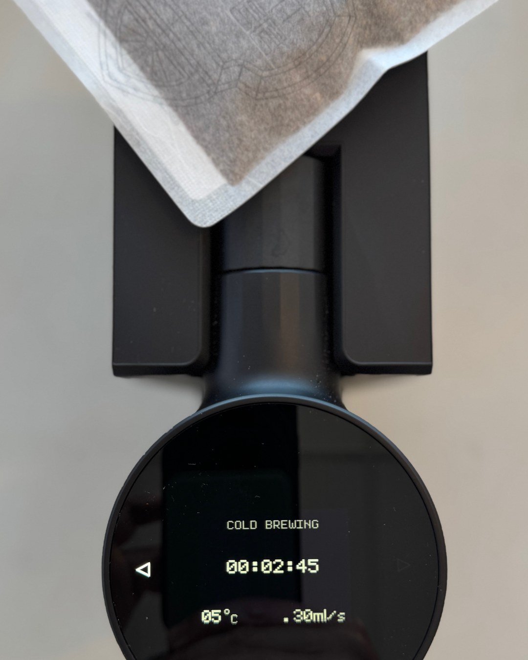 Coffee brewing device with digital display showing 'Cold Brewing' and time remaining.