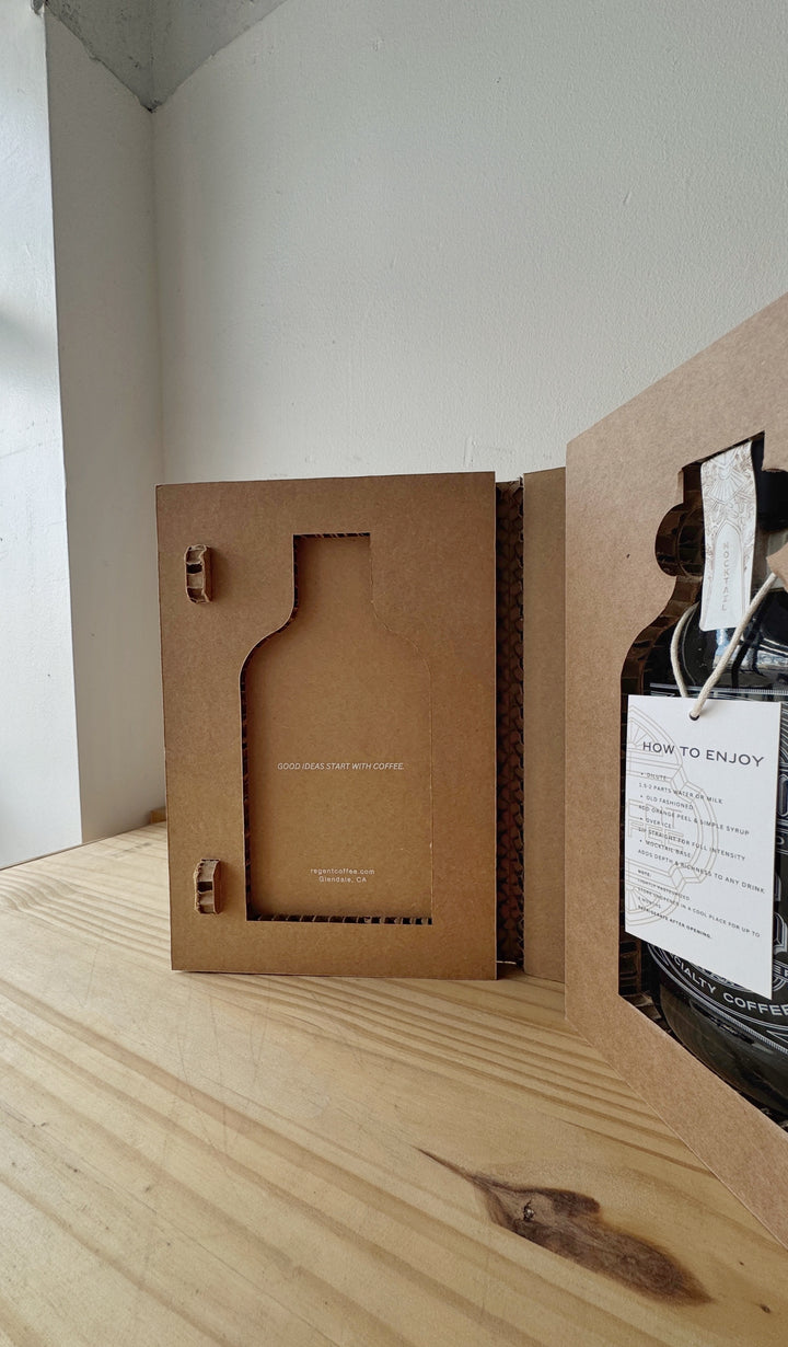 Brown cardboard box with a bottle on a wooden surface