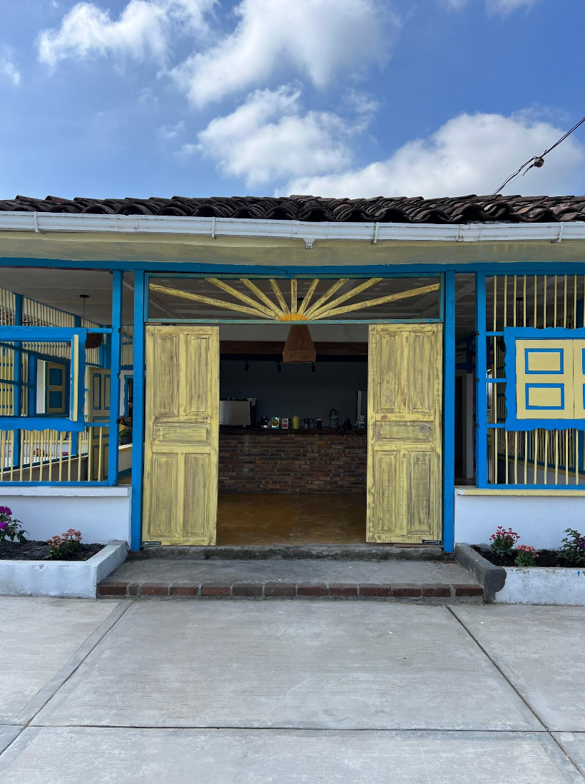 Coffee bar at Campo Hermoso tucked behind yellow wooden doors and blue painted wooden beams