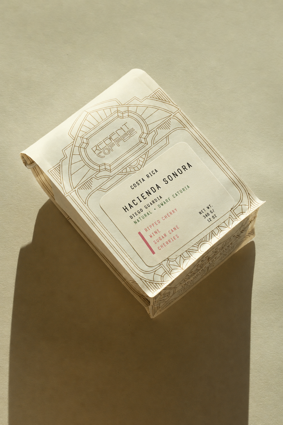 A package of Hacienda Sonora Coola Rica Bold Coffee Roasted, shown at an angle on a warm beige background with a soft shadow.